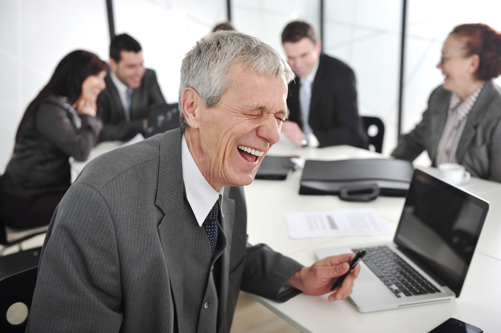 Senior businessman laughing at office meeting