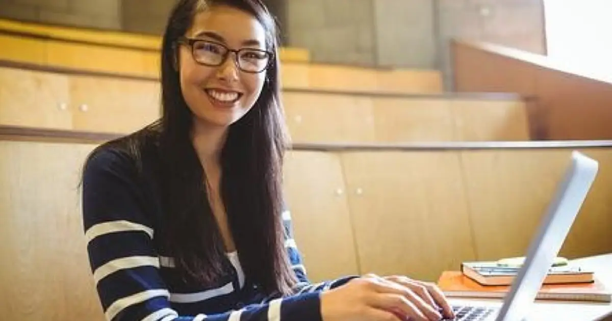 smiling-student-using-laptop-at
